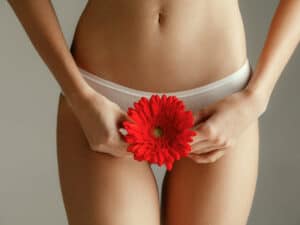 Femme qui a ses règles avce une fleur rouge