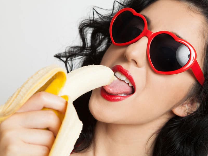 Femme avec lunette de soleil léchant une banane lovatoy